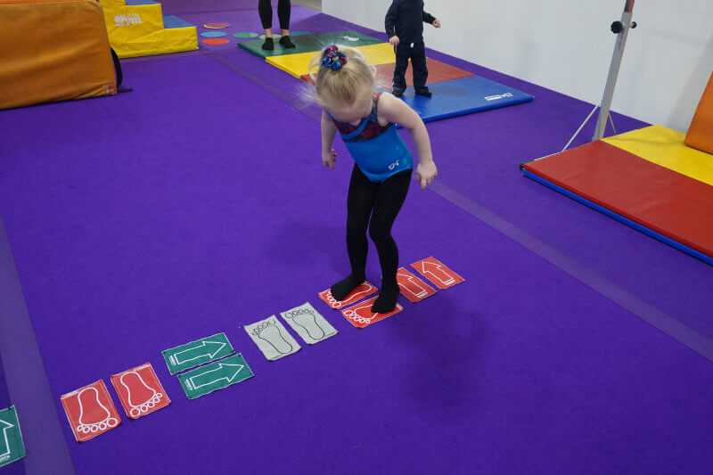 Toddler practicing foot placement, balance, and coordination in Kangaroos class